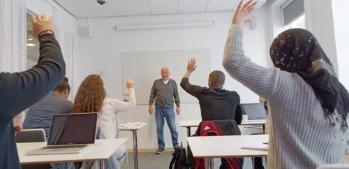 Klassrum där elever räcker upp handen