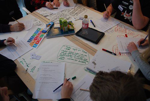 Ungdomar och äldre skriver idéer och tankekartor tillsammans